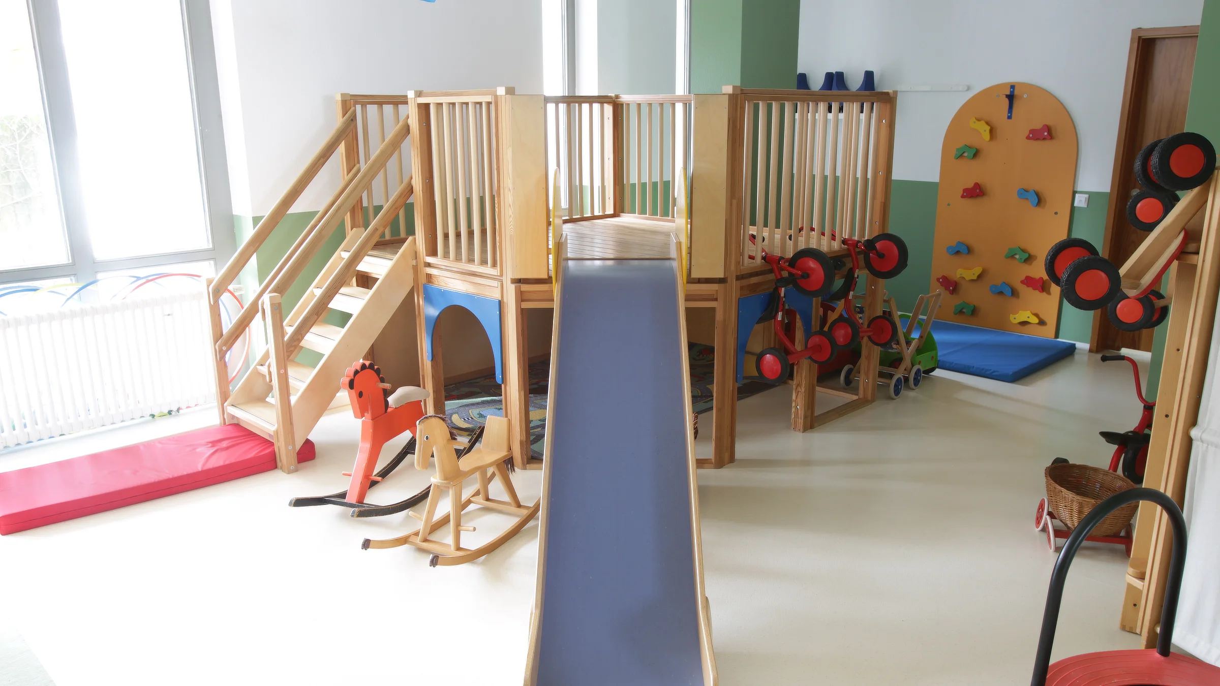 Gruppenraum mit Rutsche, Rollern, Trampolin und Kletterwand